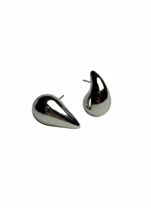 Pair of shiny silver teardrop stud earrings on white background